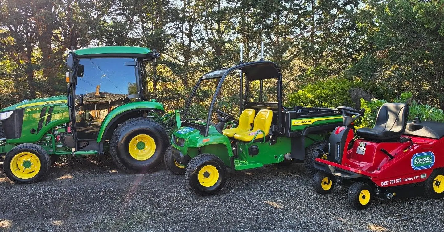 John Deere tractor, utility vehicle and Ongrade branded turf sweeper parked together
